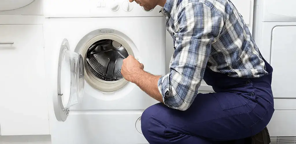 Handyman inspecting a dryer drum and internal parts for repair in Fort Wayne, IN