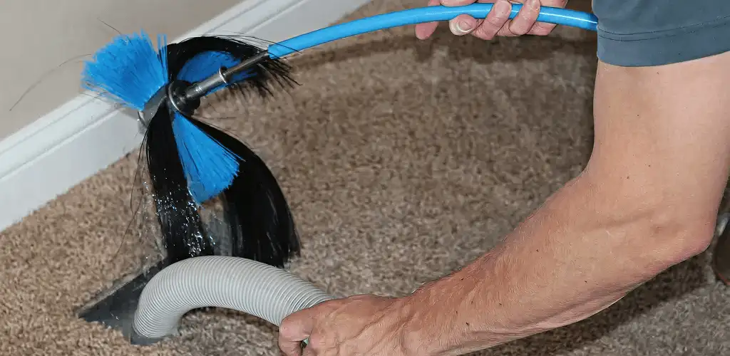 Dryer vent cleaning technician brushing lint from a vent line in Fort Wayne, IN
