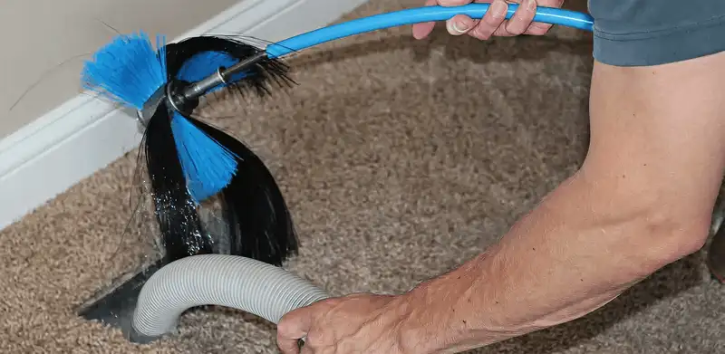 Dryer vent cleaning technician brushing lint from a vent line in Fort Wayne, IN