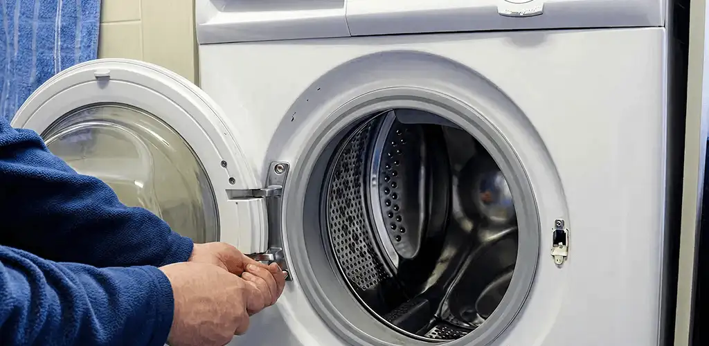 Washing machine repair handyman checking a front-load washer door and latch in Fort Wayne, IN