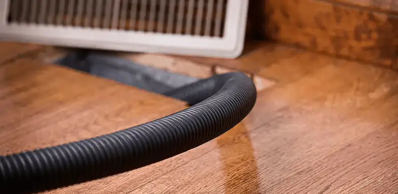 Air duct cleaning hose inserted into a floor vent for ductwork cleaning in Fort Wayne, IN