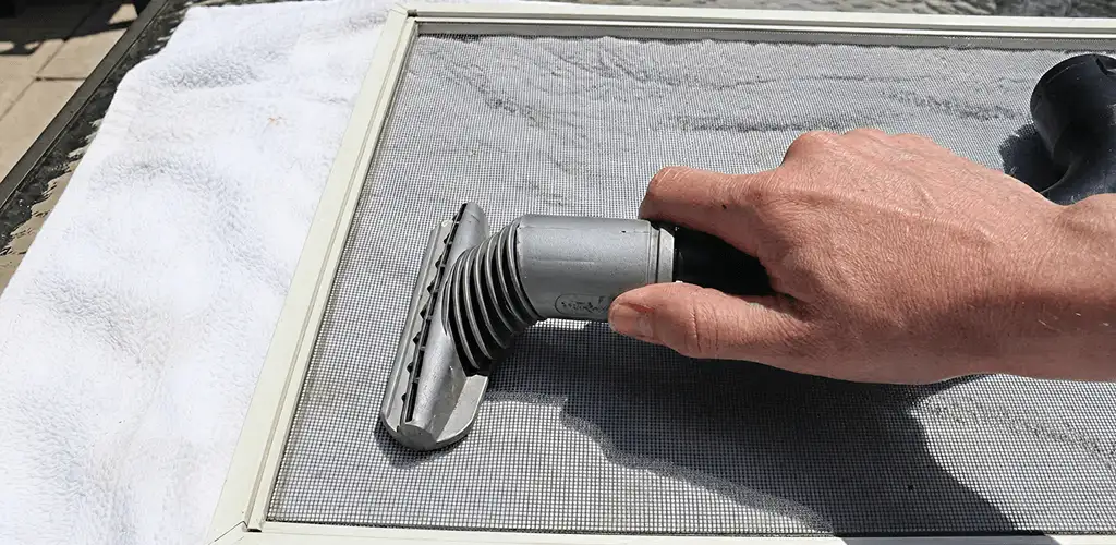 Window screen repair cleaning and fixing a damaged screen mesh in Fort Wayne, IN